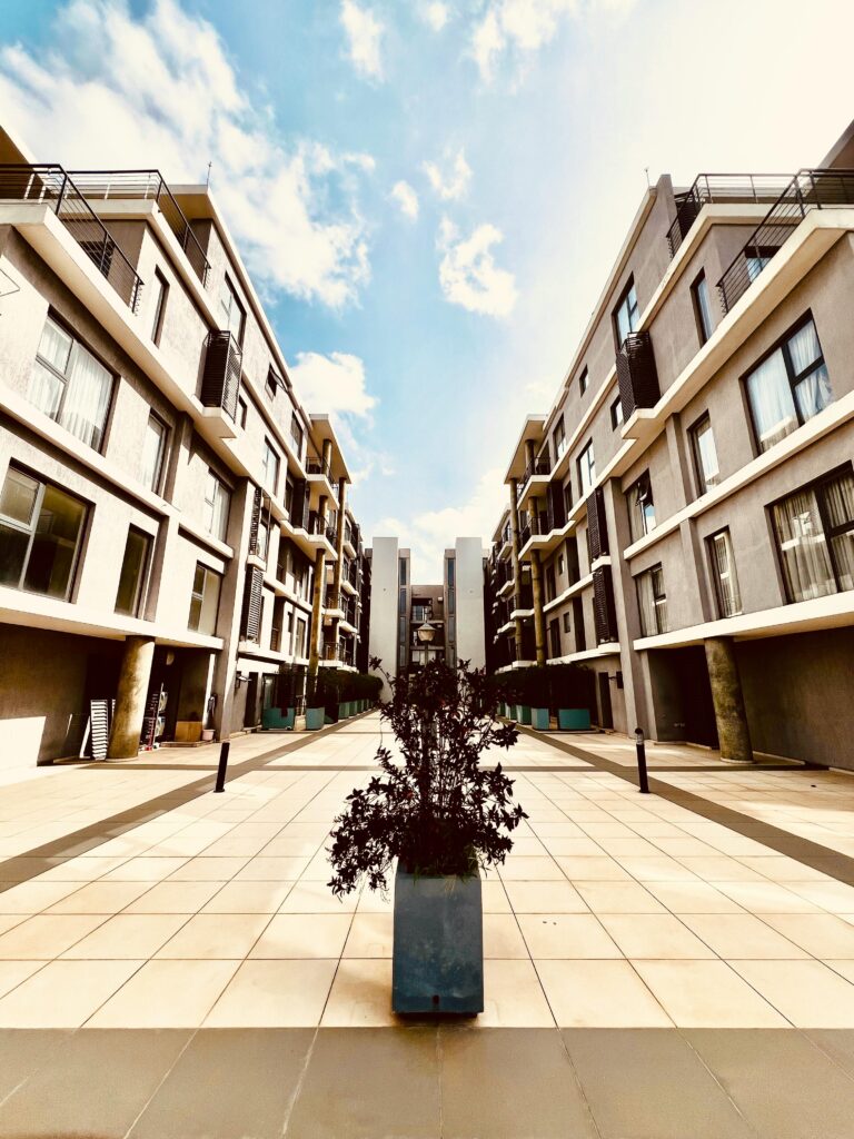 Symmetrical view of a modern apartment complex under a bright blue sky.